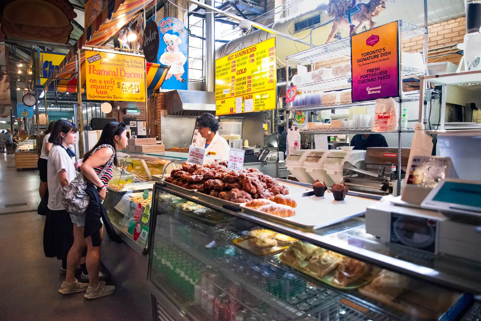 Shoppers at a deli counter inside St. Lawrence Market in Toronto